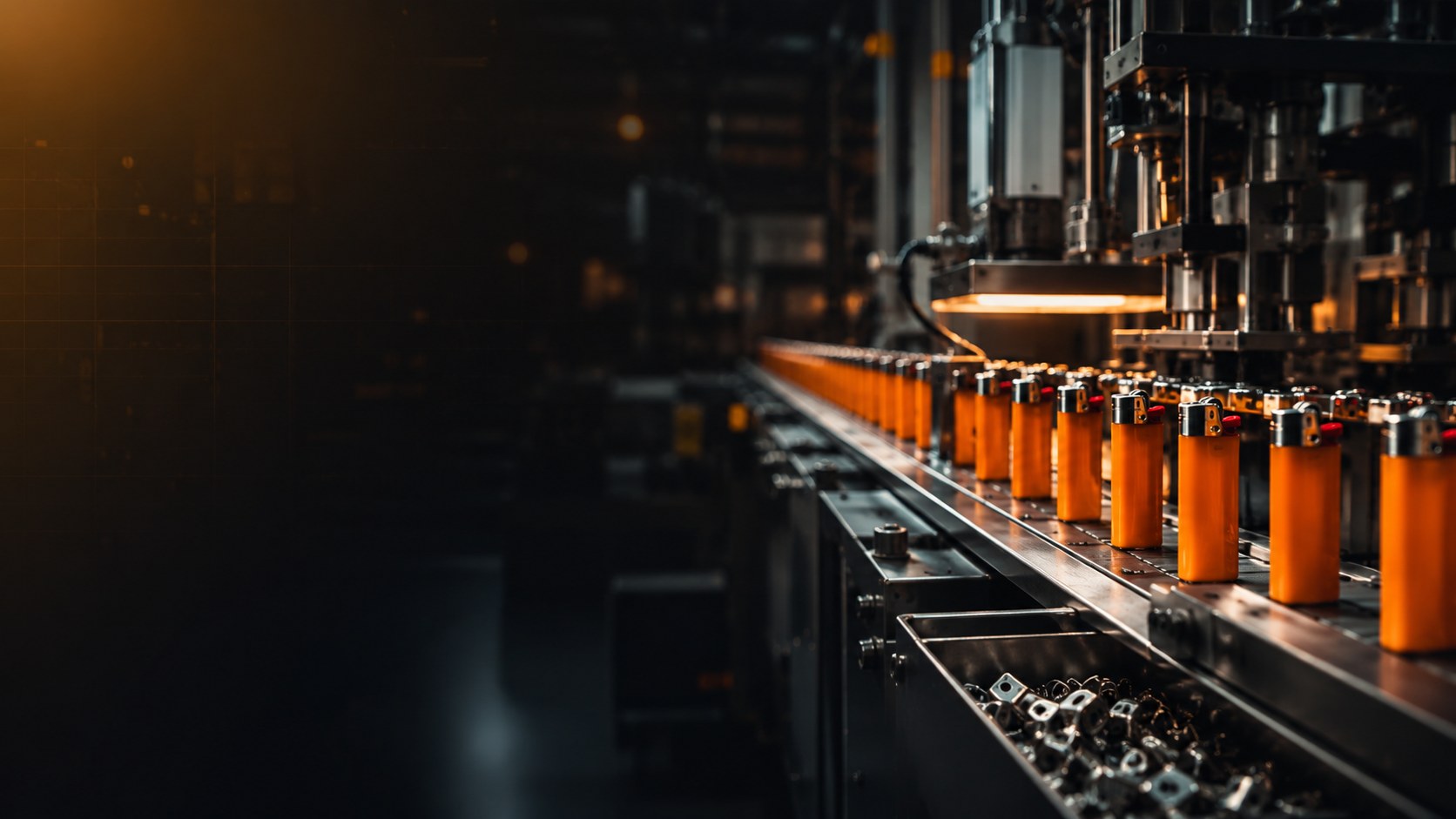 Dark automated lighter production line with orange lighters on a conveyor